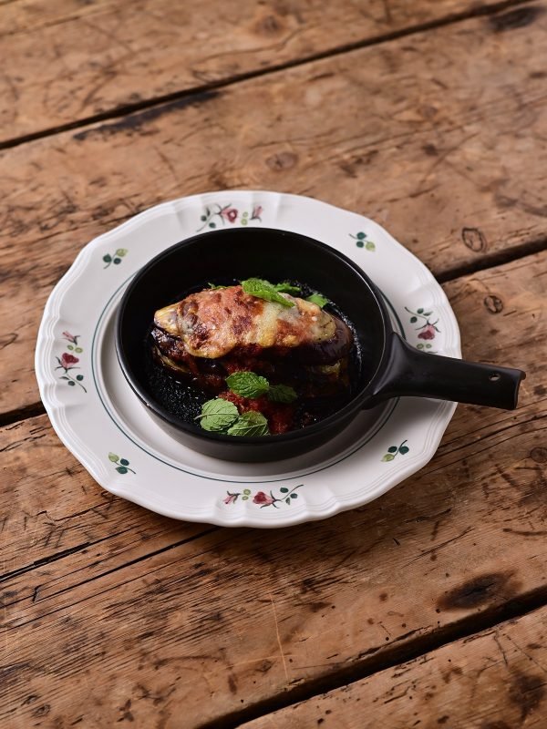 Studio M’ Rosier 圓餐盤上面放着一個裝着食物的小平底鍋放在餐抬上。