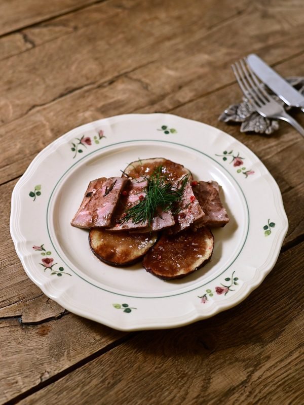 Studio M’ 2025 秋冬新系列 Rosier 圓餐盤裝着食物放在木枱面,旁邊有刀叉。