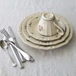 三個大小不同的 Studio M' Rosier 圓餐疊、上面倒放着起Rosier 茶杯放在餐抬上，邊有刀叉、匙羹等。