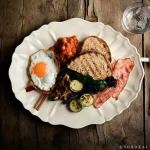 白色款 STUDIO M' Sobokai Communus 饗宴浮雕盤 (32.5cm) 裝着食物放在木餐桌上的俯視圖。