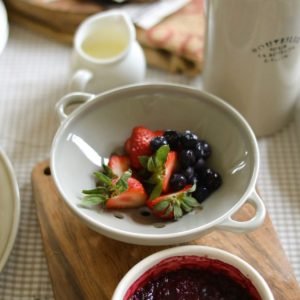 Studio M' Berry 雙耳瀝水碗 灰色款裝着莓菓放在木板上的近距離圖片。