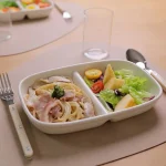 Studio M' Aeroport 雙格盤裝着沙律放在枱上，兩邊各放了一把叉與匙羹。