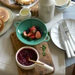 薄荷綠款 Studio M’ Berry 雙耳瀝水碗裝着草莓等放在枱上的俯視圖。