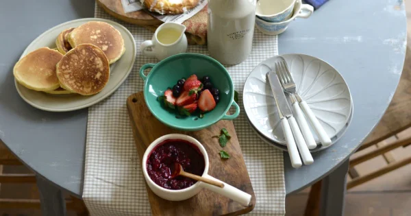 薄荷綠款 Studio M’ Berry 雙耳瀝水碗裝着草莓等放在枱上的俯視圖。