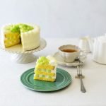 白色款Studio M’ Biscuiterie 波浪邊高腳托盤上放了蛋糕，與其他茶壺、茶杯等放在桌子上，另外有一個裝了蛋糕的碟放在旁邊。