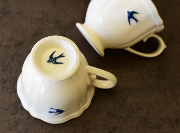 二個 Studio M' Early Bird 燕子系列茶杯一個打側、一個底部向上放在枱上。