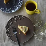 啡色及深灰色款Studio M' MINT 浮雕餐盤上面裝着甜點一起放在枱上的俯視圖。