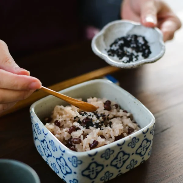 用匙羹從藍色 Studio M' Nobana 野花二段疊盒取出飯