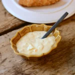 焦糖色 Studio M' Rakott Krumpli 烤盤 SS尺碼款裝着醬汁、放了匙羹放在裏面放在枱上。