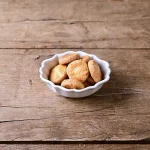 白色Studio M' Rakott Krumpli 烤盤 SS尺碼款裝着餅乾放在木枱上。