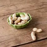 橄欖綠 Studio M' Rakott Krumpli 烤盤 SS尺碼款裝着花生放在木枱上。