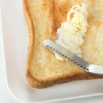 用吉川不銹鋼牛油刀把牛油刷到麵包上