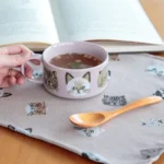 粉紅色 CDF ètendue I LOVE CAT!貓咪湯碗裝着湯放在枱上,旁邊放着木湯匙