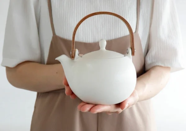 SALIU YUI 祥「結」日本製美濃燒日式茶壺 600ml 白色 雙手手持示意