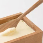 日本製山櫻木牛油盒蓋子打開,木匙羹放在牛油盒內的牛油中的示範