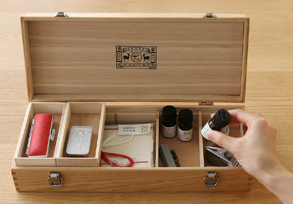 日本製 扁形木製工具收納箱, 手從打開的收納箱中取出物品展示