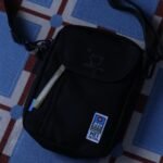 MEI OCEAN × Miffy 長形斜揹袋 黑色, 藍色背景平放俯視展示二