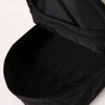 從上往下看是一個打開的 Miffy 黑色背包，露出寬敞的主隔層和頂蓋內側的拉鍊內袋。內部是空的，光滑的布料讓它看起來很時尚。.