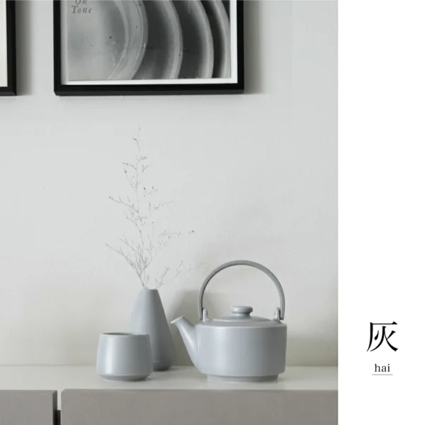 日本製 SALIU 緣 土瓶急須 400ml - 灰色款茶壺乳同系列茶杯及花瓶放在牆壁前面枱上展示